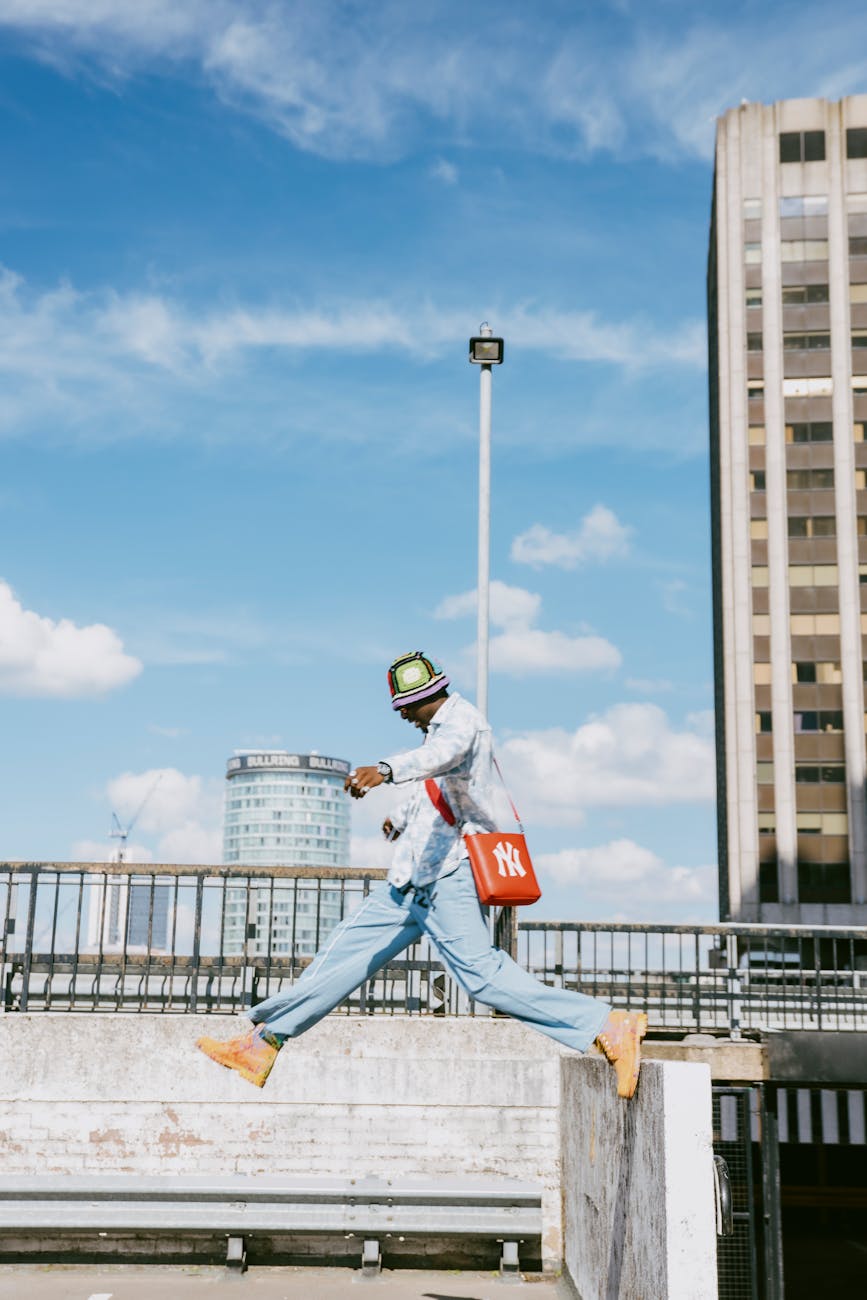 man in jean jacket jumping from wall - confidence